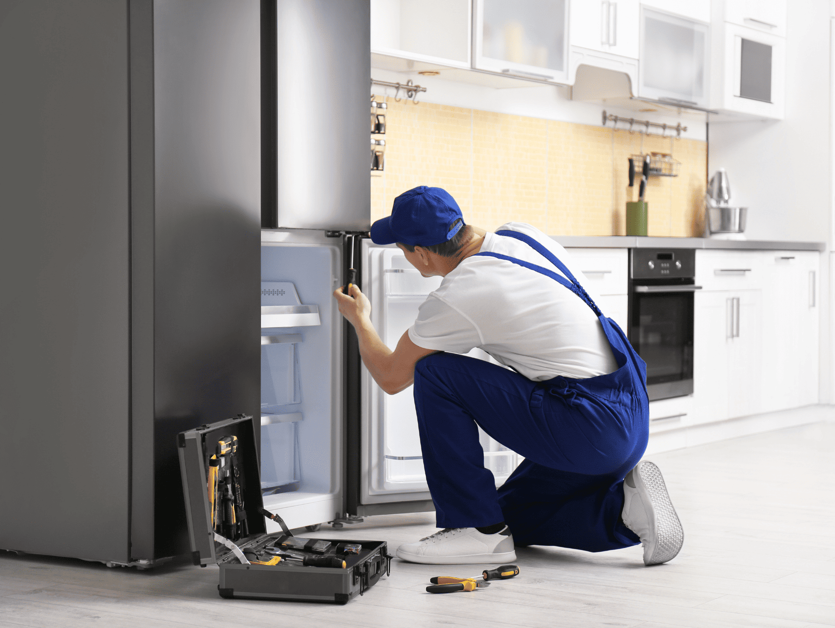 Appliance repair technician in Louisville, KY, fixing a refrigerator
